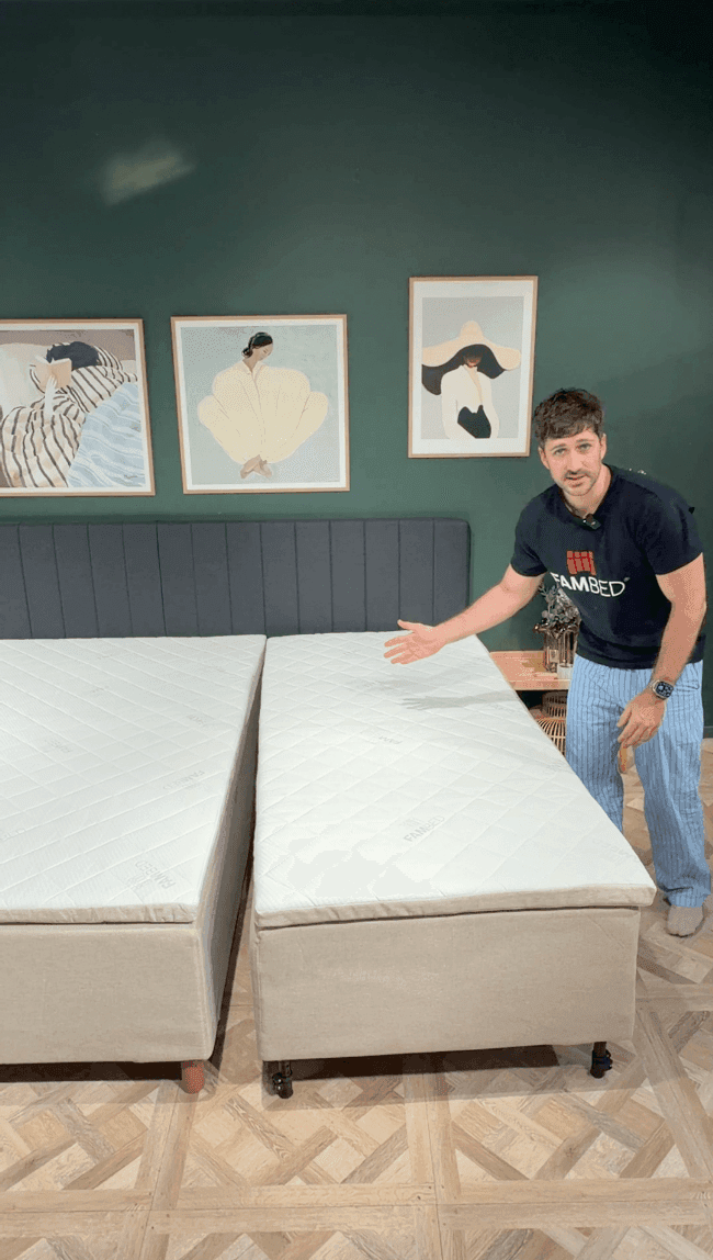 Un uomo mostra il letto aggiuntivo su ruote, accostato perfettamente al letto esistente