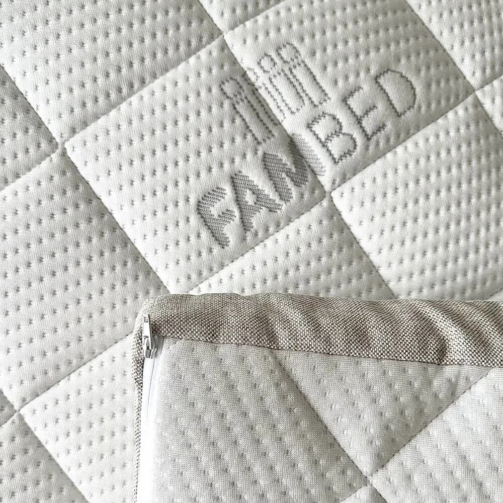 Primo piano del rivestimento bianco trapuntato del topper, con logo FAMBED intessuto