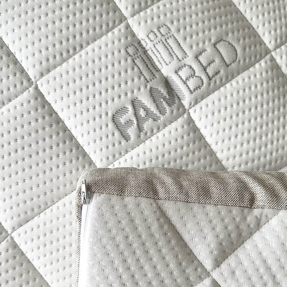 Primo piano del rivestimento bianco trapuntato del topper, con logo FAMBED intessuto