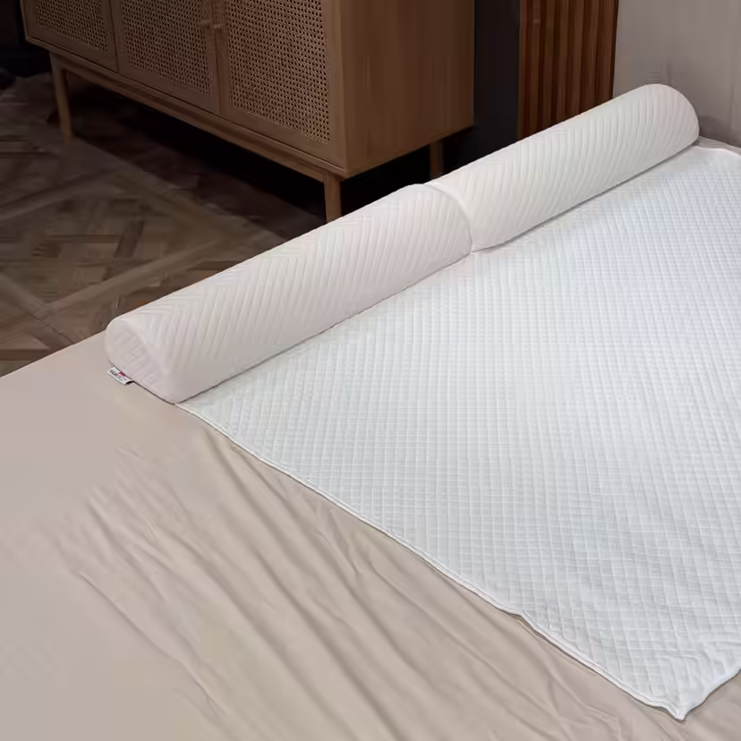 Barriera letto trapuntata in schiuma, inserita sotto il rivestimento bianco del topper lungo il bordo del letto